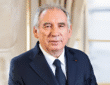 François Bayrou speaking at a political event, wearing a suit and tie.