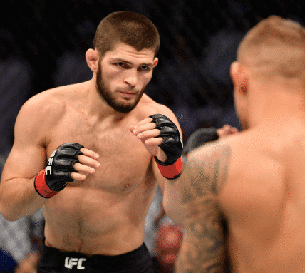 Khabib Nurmagomedov standing in the UFC Octagon after a fight, holding the lightweight championship belt.