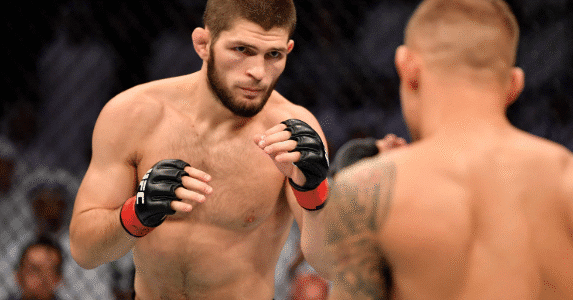 Khabib Nurmagomedov standing in the UFC Octagon after a fight, holding the lightweight championship belt.