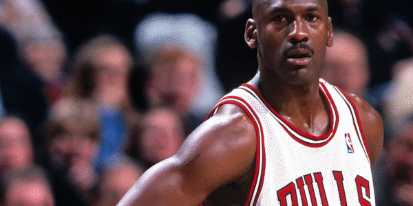 Michael Jordan biography portrait during an NBA game showcasing his iconic jump shot and Air Jordan sneakers